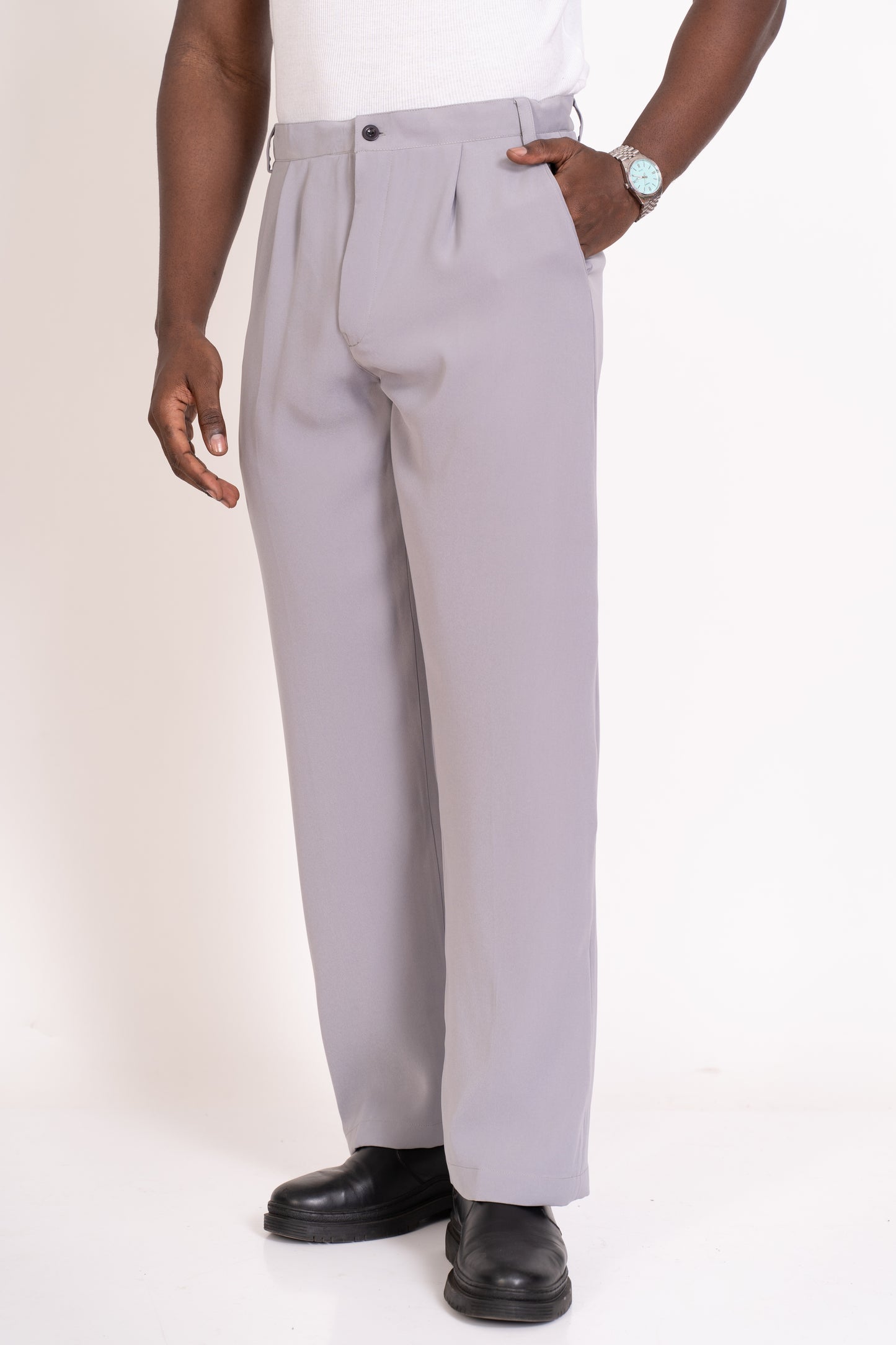 Person wearing strada light grey pleated pants on a white background