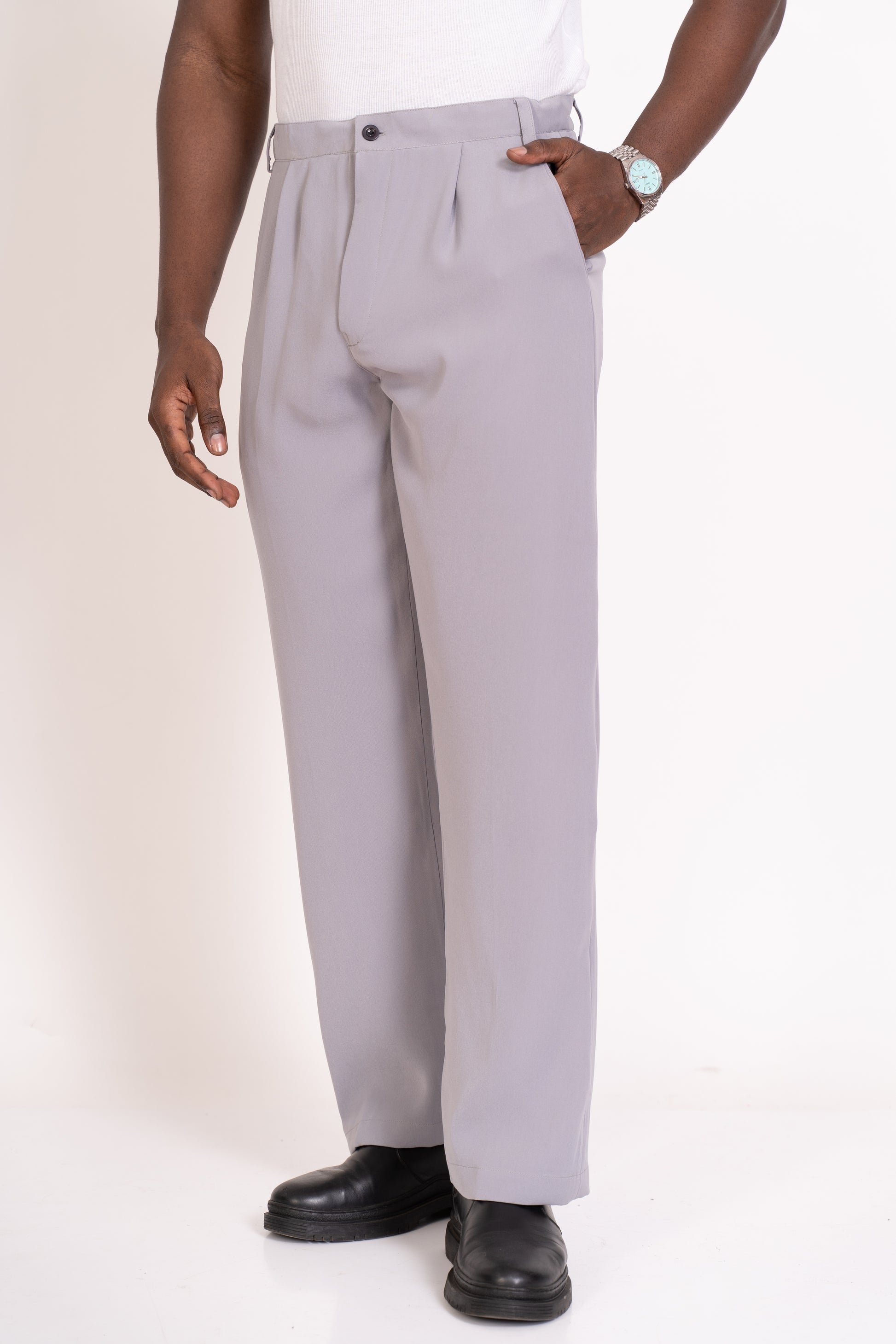 Person wearing strada light grey pleated pants on a white background