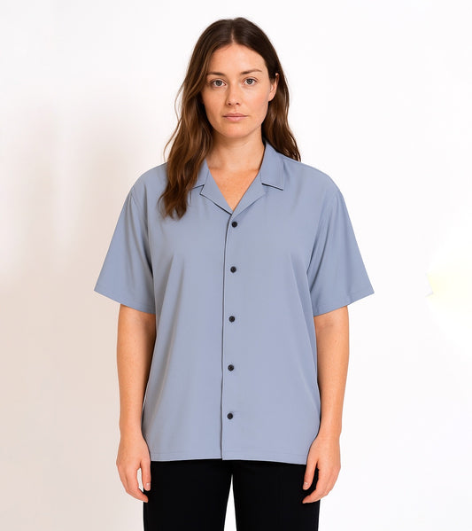 Woman wearing strada bowling club light blue short-sleeve shirt with buttons on a white background