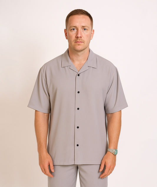 Man wearing strada bowling club light grey short-sleeve button-up shirt against a beige background